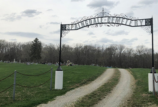 Entry gate reading Springdale Cemetery in front of a cemetery